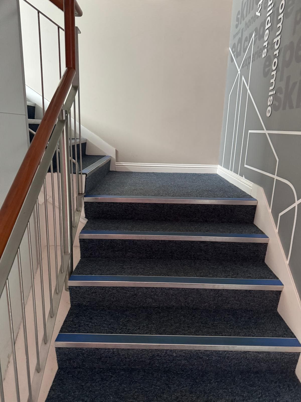 Refreshed stairwell carpet against blue risers