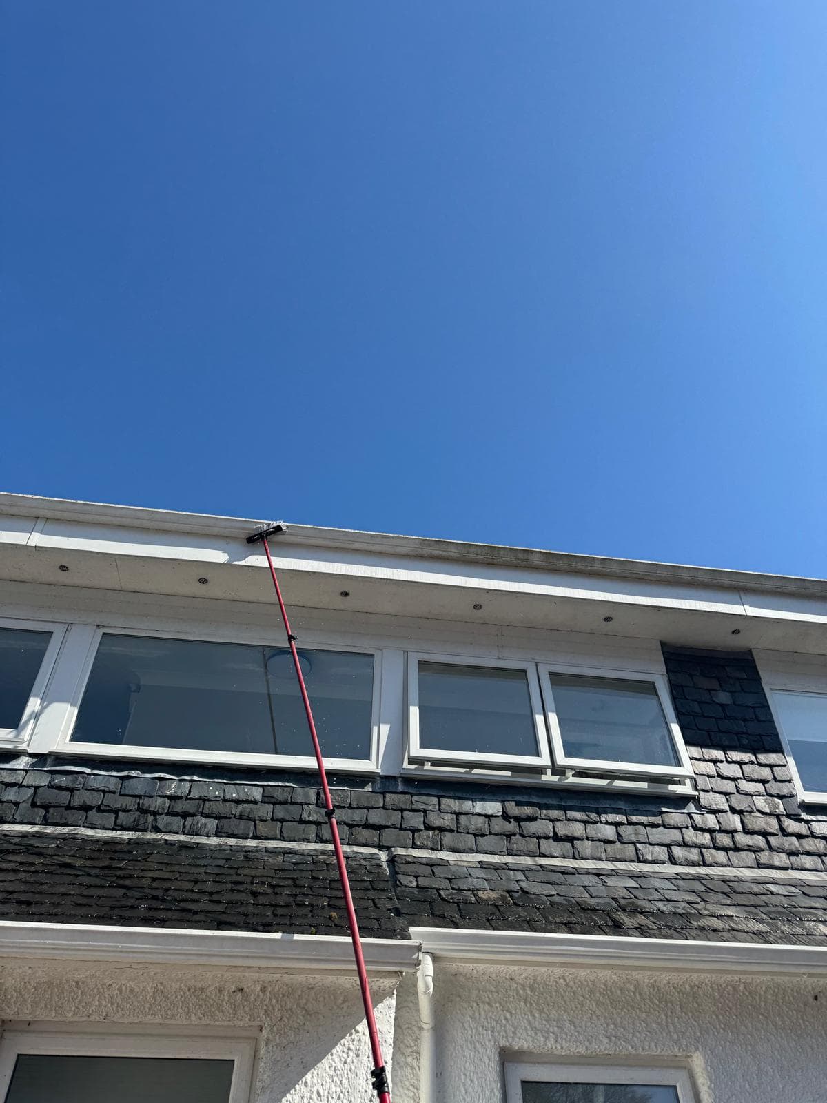 Operator with telescopic pole at roof line