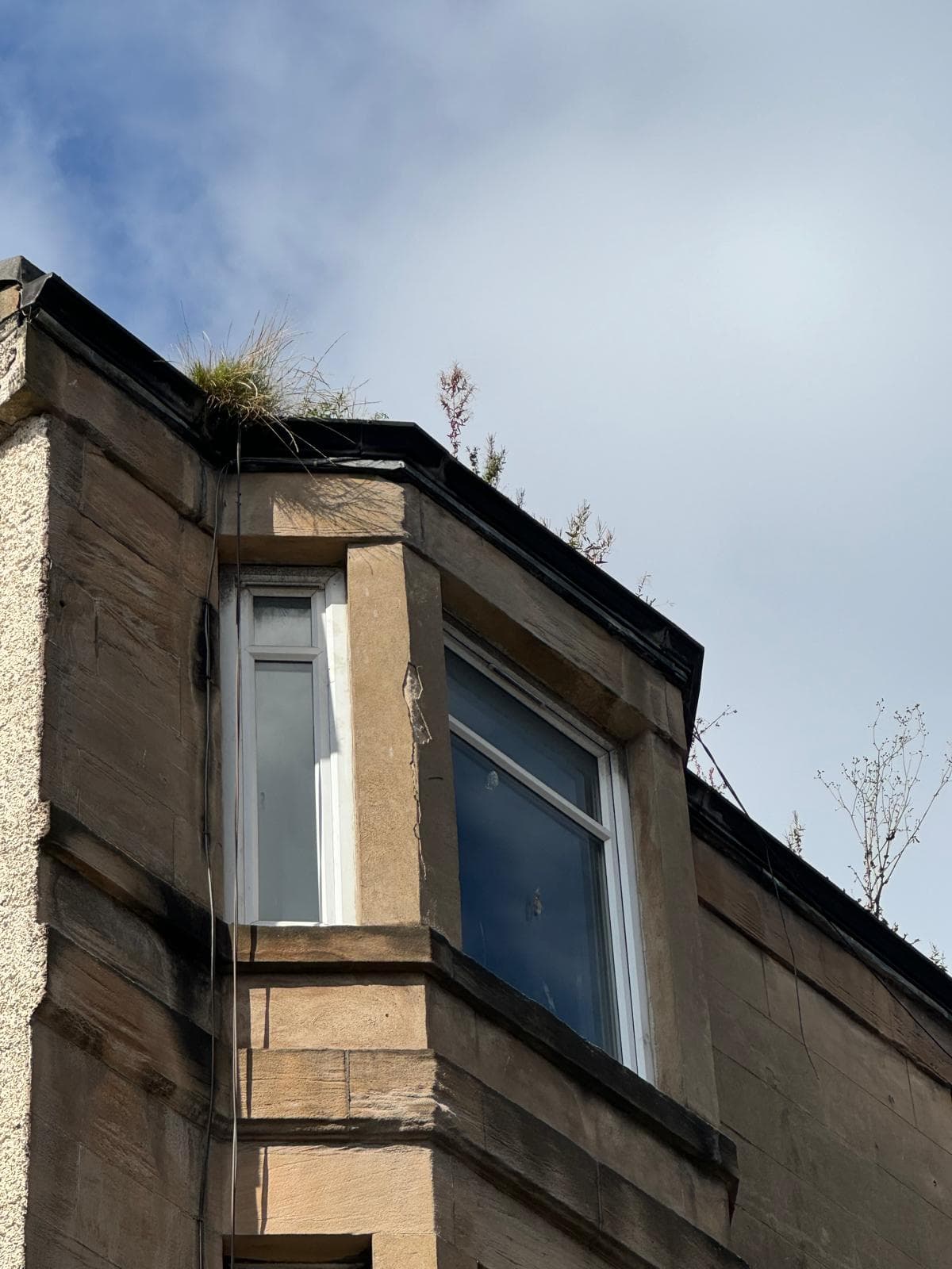 Stone facade gutter being cleared