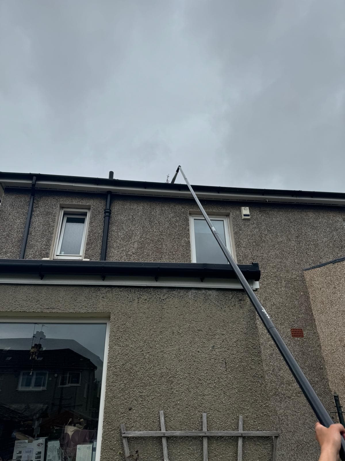Telescopic carbon pole on residential gutter